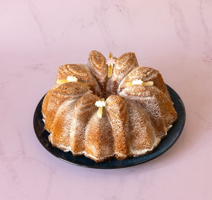 Lemon and poppy seed Bundt cake on black serving plate