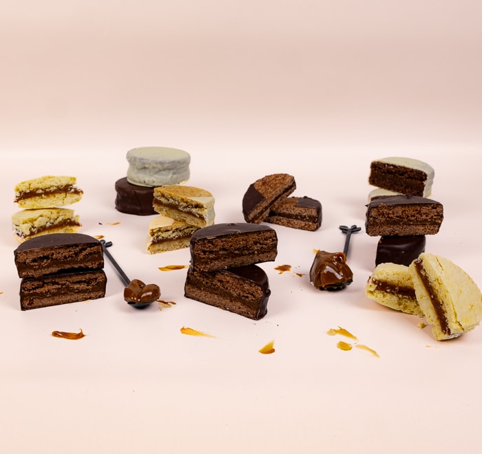 Mixed alfajores with teaspoons of dulce de leche