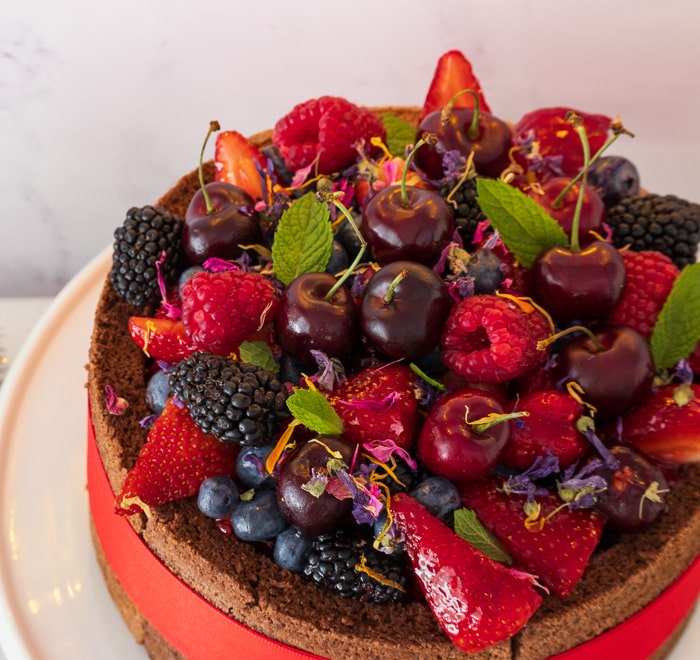 Close up of Raspberry Bavarois cake decorated with various fruit berries