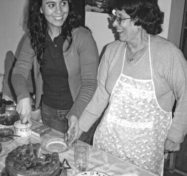 Silvina with her Mum at home serving home baked cake